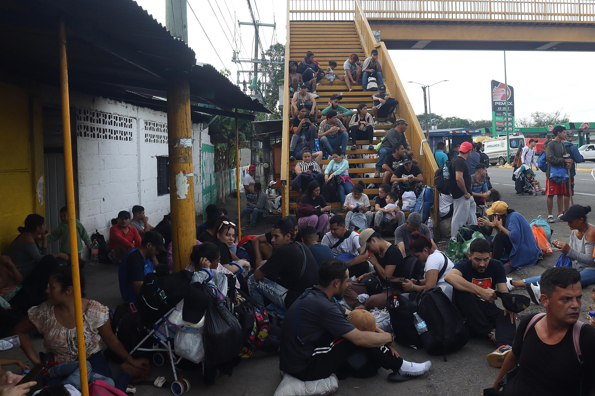 Migrantes descansan sobre una vía este lunes, en el municipio de Huehuetán (México). EFE/ Juan Manuel Blanco
