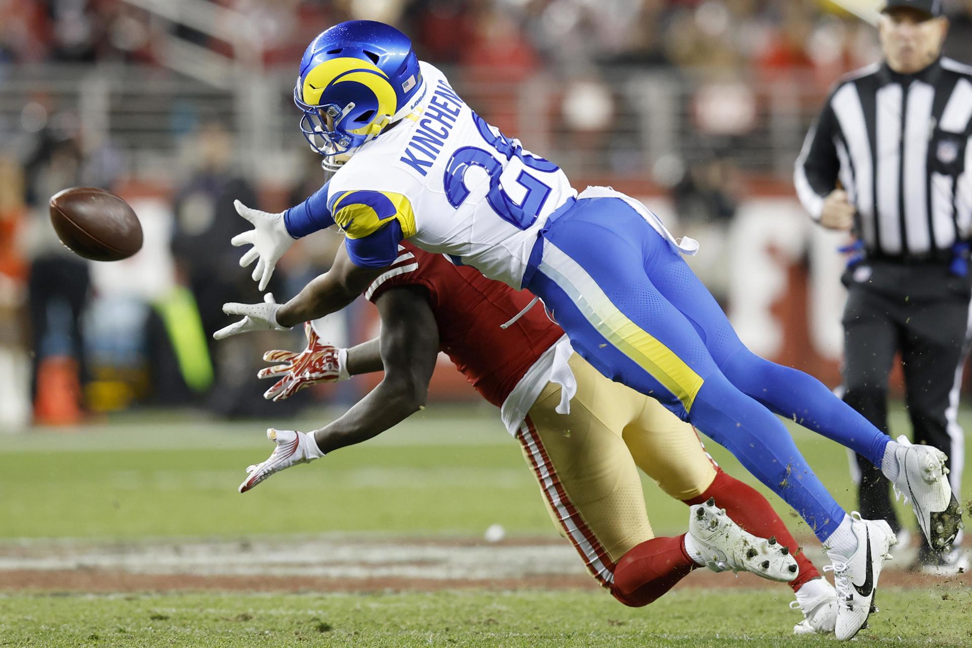 El receptor de los San Francisco 49ers, Deebo Samuel Sr. (i), y el safety de Los Angeles Rams, Kamren Kinchens, luchan por el balón durante el juego de este jueves en Santa Clara (California). EFE/EPA/JOHN G. MABANGLO
