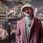 Fotografía del director de la adaptación de la obra "Cien años de soledad" para Netflix, Álex García, posando junto a las fotografías de la exposición del proceso de construcción de la producción, durante una presentación especial celebrada en la Biblioteca Real de Bruselas. EFE/Sara Morato Núñez