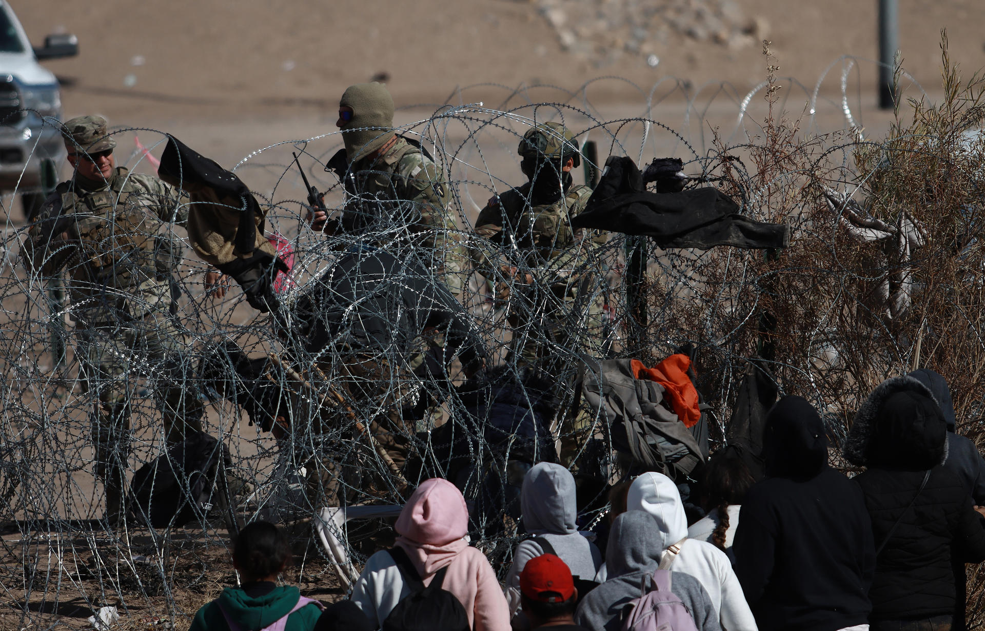 Fotografía fechada el 17 de enero de 2024, de migrantes intentando cruzar vallas de puas en la frontera que divide a México de los Estados Unidos en Ciudad Juárez en Chihuahua (México). EFE/ Luis Torres
