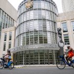 Transeúntes en bicicleta pasan frente a la corte de Brooklyn en Nueva York (EE.UU.). Archivo. EFE/ Ángel Colmenares