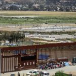 Imagen de archivo de migrantes que permanecen en la línea divisoria entre México y EEUU, en Tijuana (México). EFE/ Joebeth Terriquez