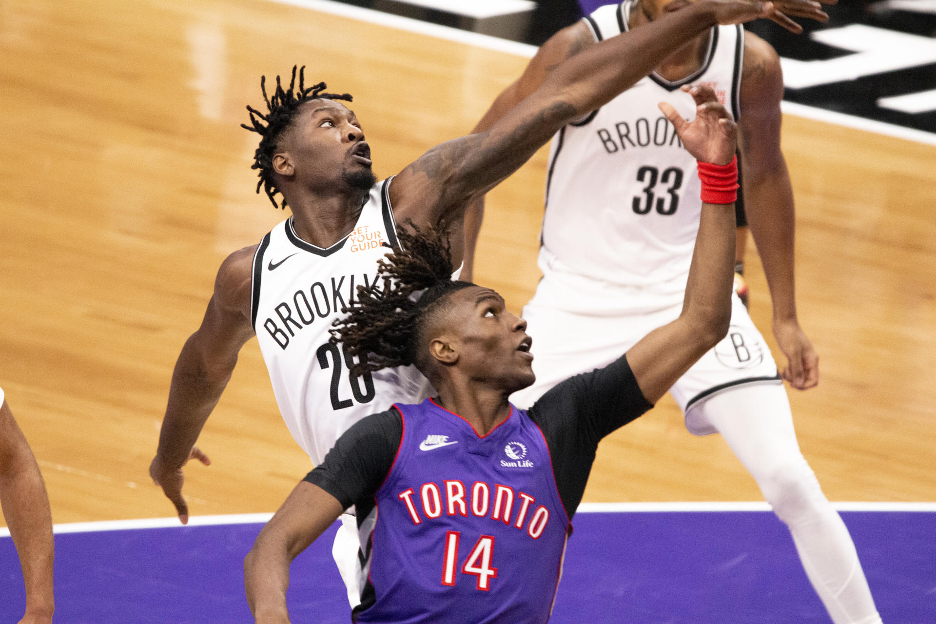 Ja'Kobe Walter (abajo), de los Toronto Raptors disputa un balón con Dorian Finney-Smith de los Brooklyn Nets, durante el partido en el Scotiabank Arena en Toronto (Canadá). EFE/ Julio César Rivas
