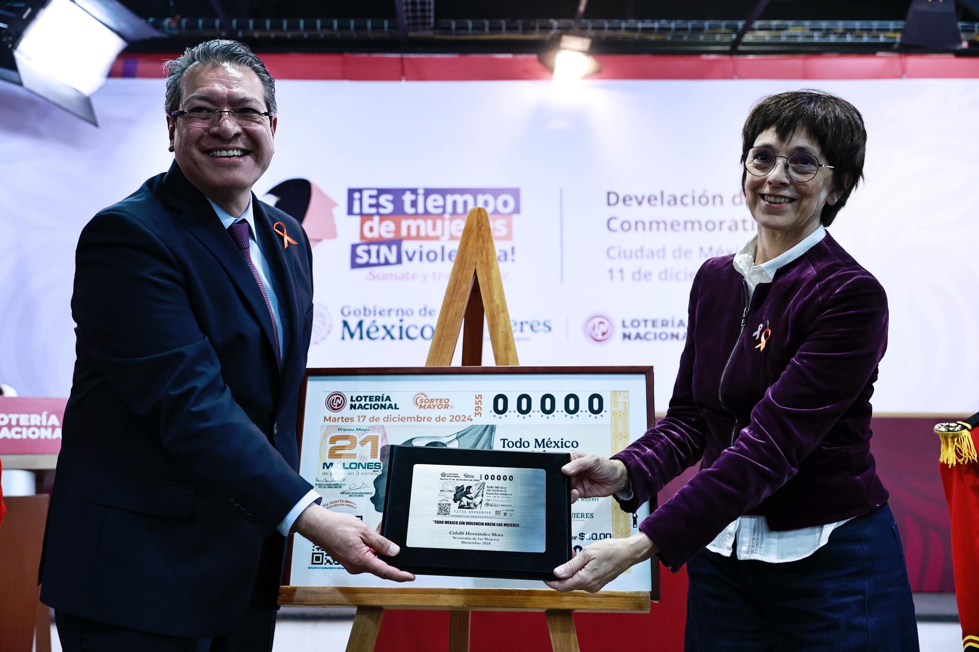 El director general de la Lotería Nacional, Marco Antonio Mena Rodríguez (i) y la directora general de la Política Nacional de Igualdad del Instituto Nacional de las Mujeres, Marta Ferreyra (d), posan durante la develación del billete de lotería 'Es tiempo de mujeres' este miércoles en Ciudad de México (México). EFE/Sáshenka Gutiérrez
