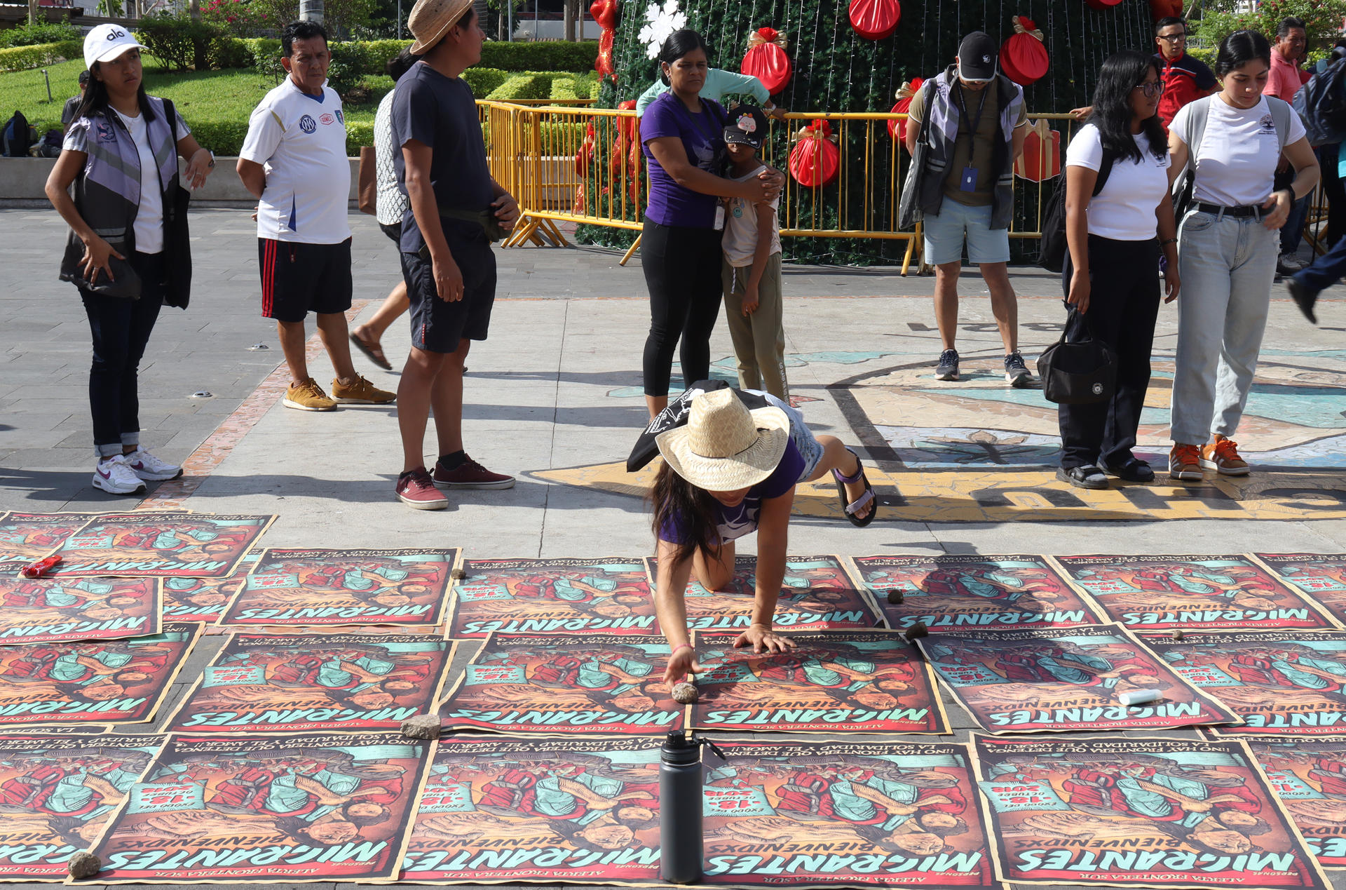 Migrantes y miembros del colectivo de monitoreo de la frontera sur despliegan carteles durante una protesta este miércoles, con motivo del Día Internacional del Migrante en el municipio de Tapachula (México). EFE/ Juan Manuel Blanco
