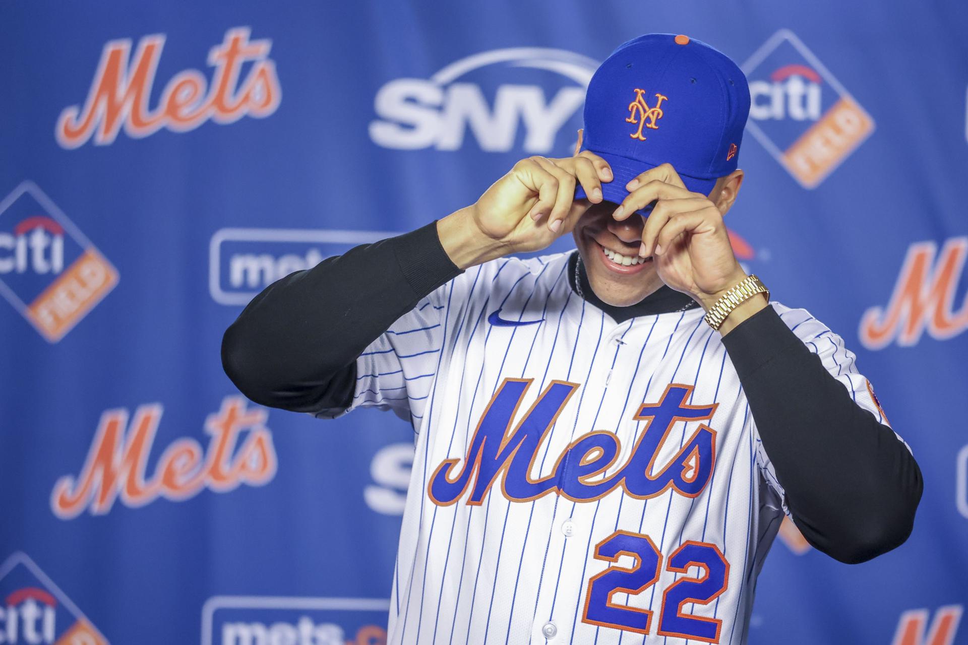 El pelotero dominicano Juan Soto se pone su nuevo gorro de los Mets durante una conferencia de prensa. EFE/EPA/SARAH YENESEL
