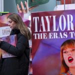 Una mujer revisa su teléfono sosteniendo el libro 'The Eras Tour Book' de la cantante estadoundiense Taylor Swift en Nueva York (Estados Unidos). Archivo. EFE/ Ángel Colmenares