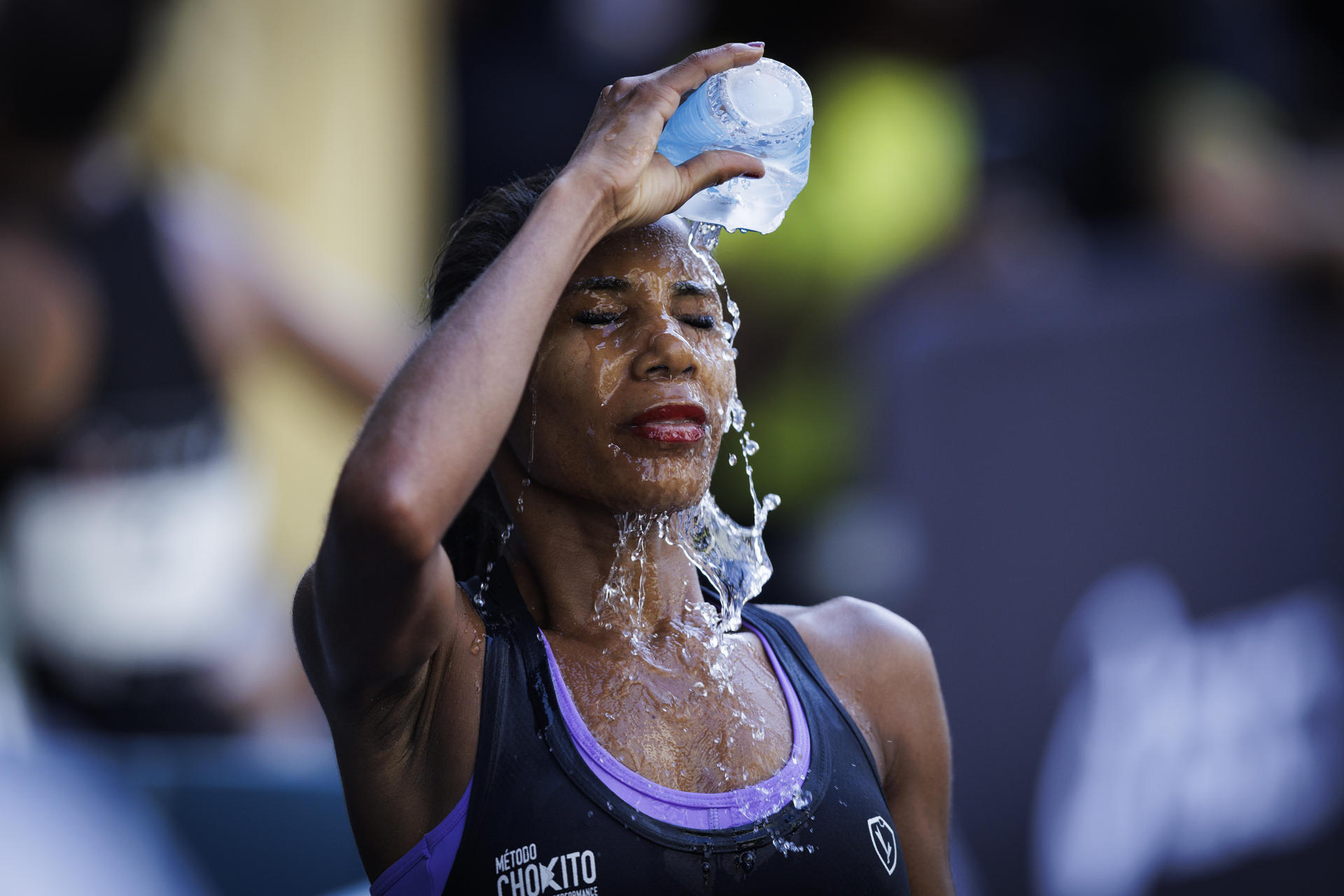 Una atleta se refresca al finalizar en la 99ª edición de la Carrera Internacional de San Silvestre en Sao Paulo (Brasil). EFE/ Isaac Fontana
