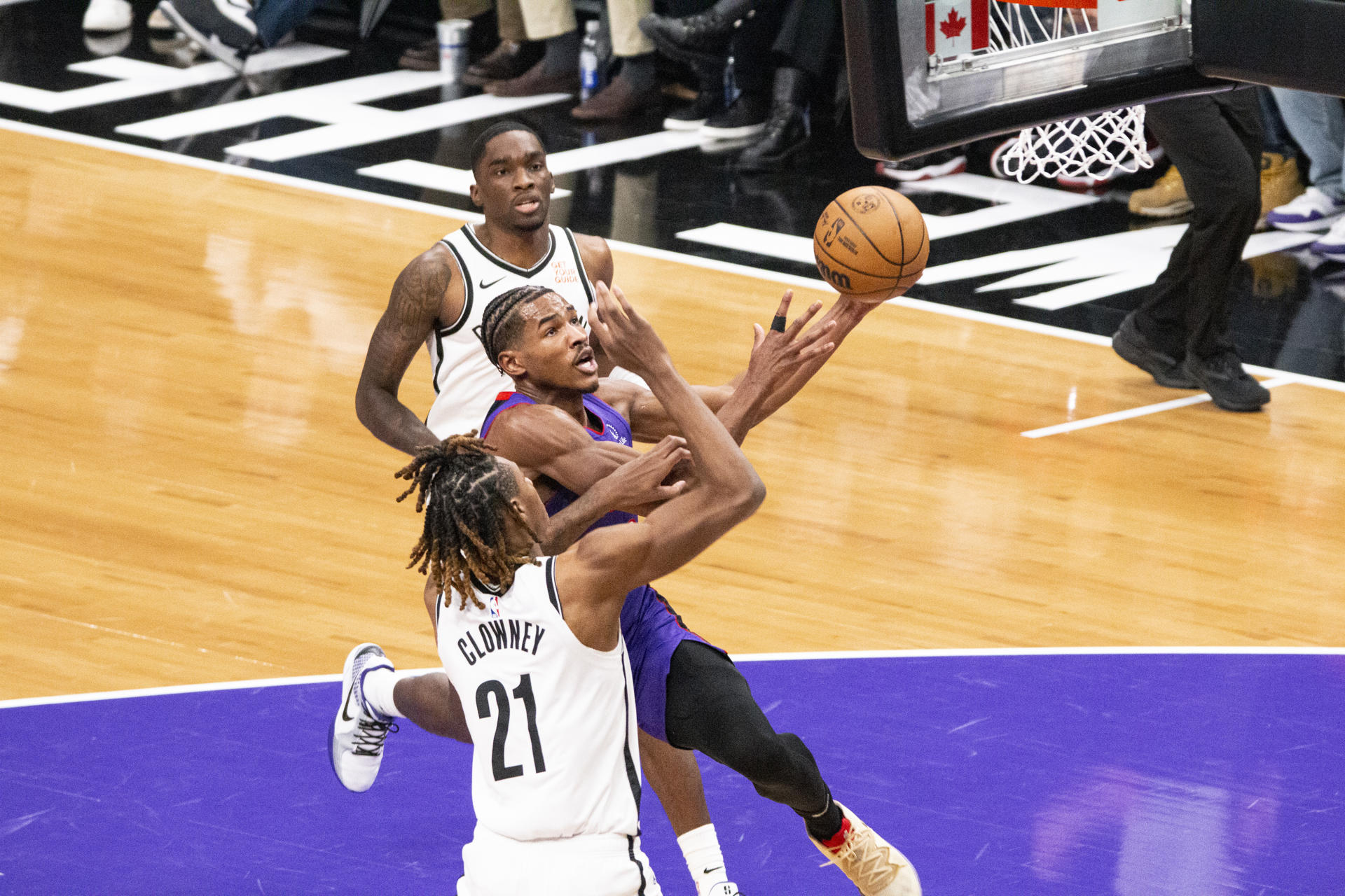 Ochai Agbaji (c) de los Toronto Raptors intenta una canasta con la oposición de Noah Clowney (abajo) de los Brooklyn Nets. EFE/ Julio César Rivas
