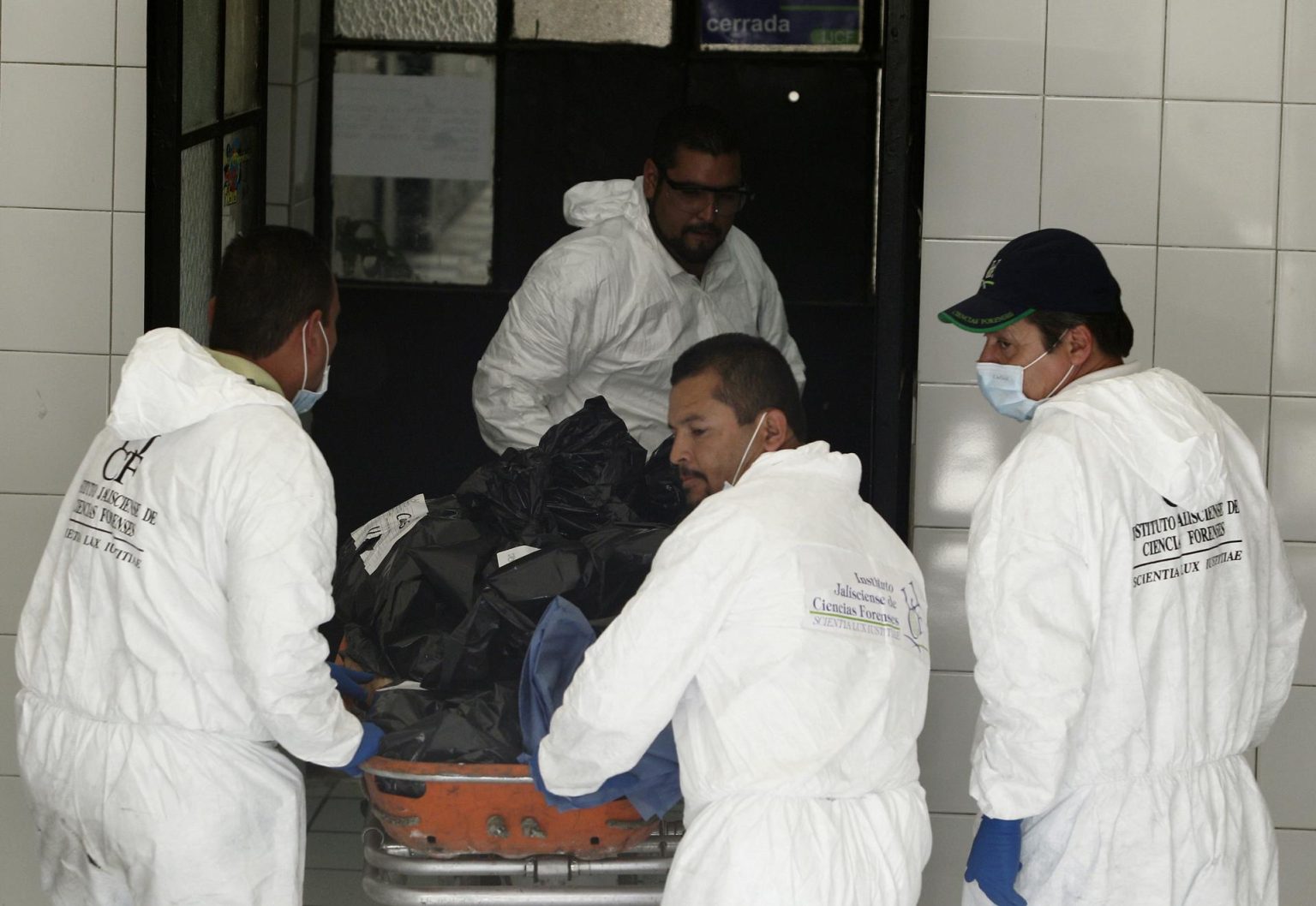 Imagen de archivo de expertos forenses que cargan bolsas con cadáveres. EFE/Ulises Ruiz Basurto