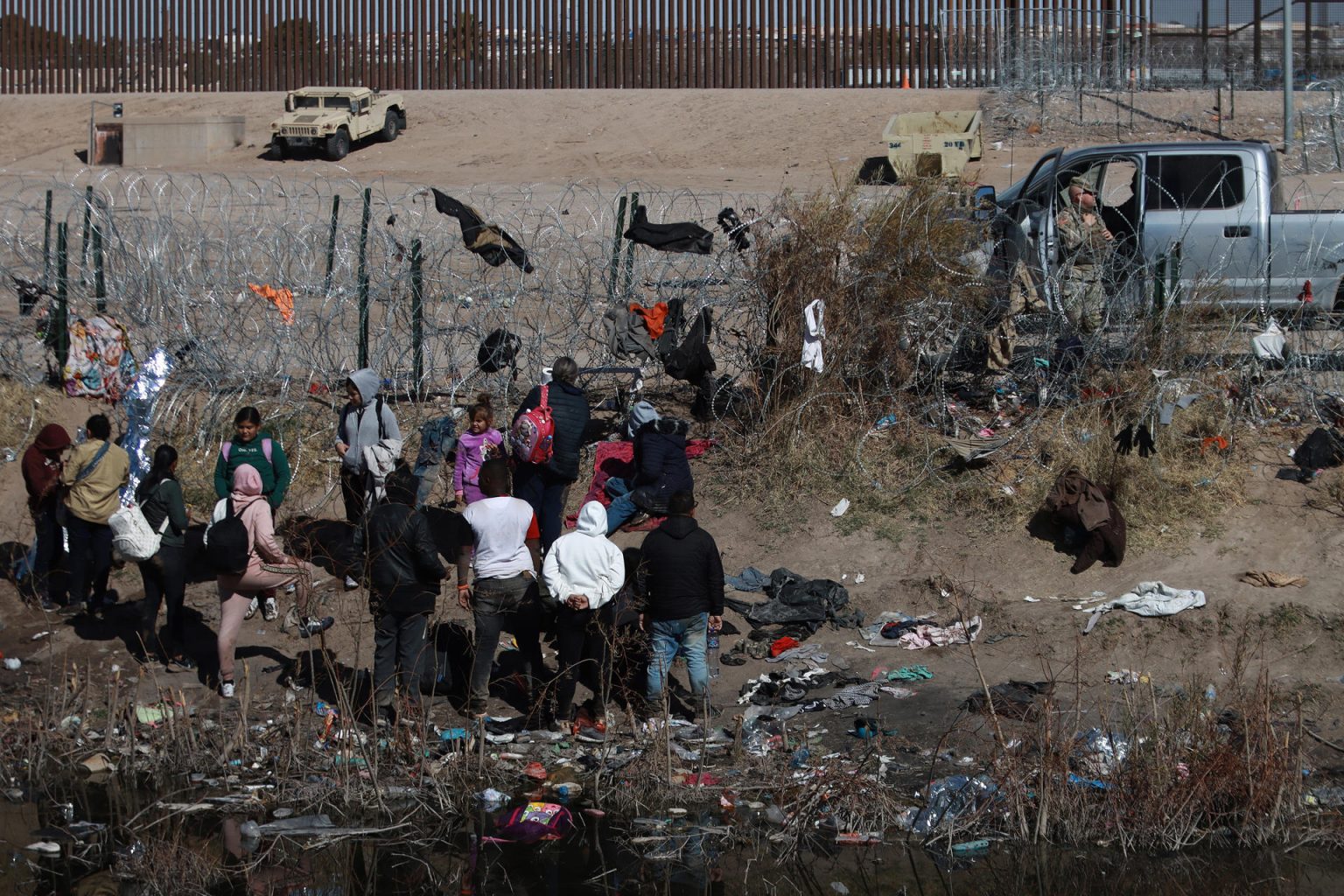 Fotografía fechada el 17 de enero de 2024, de migrantes intentando cruzar vallas de puas en la frontera que divide a México de los Estados Unidos en Ciudad Juárez en Chihuahua (México).  EFE/ Luis Torres