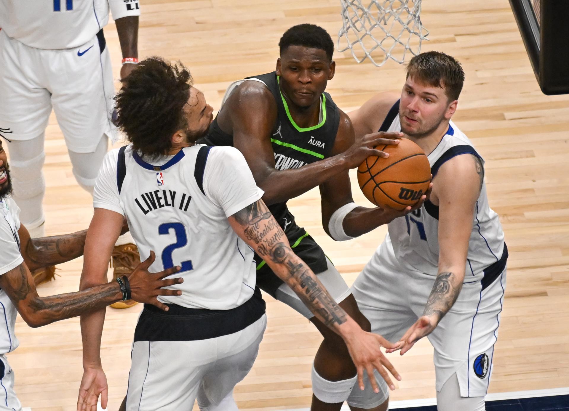 Fotografía de archivo, tomada el pasado 30 de mayo, en la que se registró a Anthony Edwards (c), guarda de los Timberwolves de Minnesota, al intentar superar la marca de Dereck Lively II (c-i) y del base Luka Doncic (d), de los Mavericks de Dallas, durante un partido de la NBA, en el coliseo Target Center de Minneapolis (Minnesota, EE.UU.). EFE/Craig Lassig
