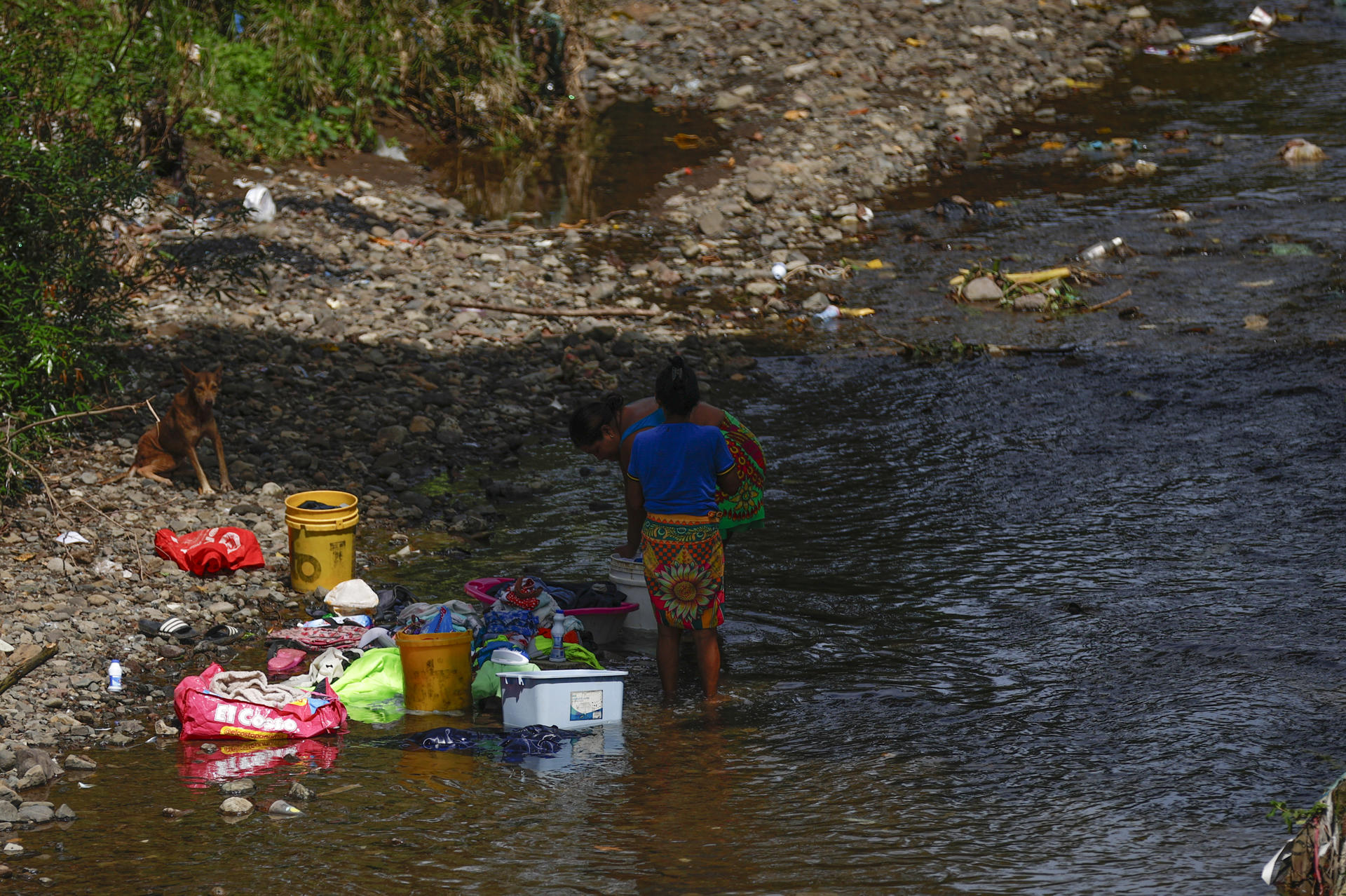 Dos mujeres lavan ropa en un río contaminado con basura, este miércoles en la comunidad de Kuna Nega, en Ciudad de Panamá (Panamá). EFE/ Bienvenido Velasco
