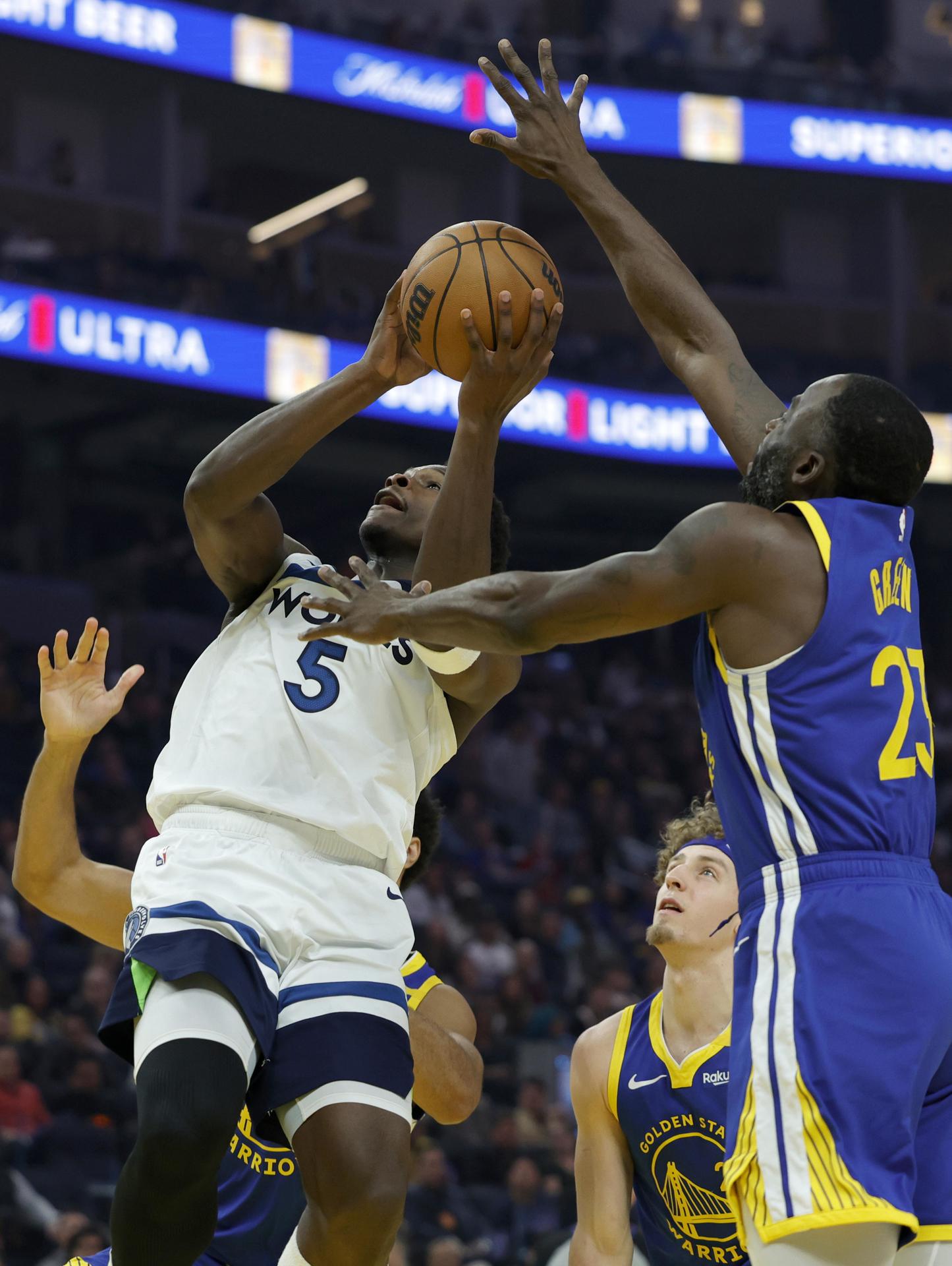 El escolta de los Timberwolves, Anthony Edwards apunta a canasta ante la presión del ala-pívot de los Golden State Warriors, Draymond Green (d), durante el juego que este vieres ganó la franquicia de Minnesota por 90-107. EFE/EPA/JOHN G. MABANGLO SHUTTERSTOCK