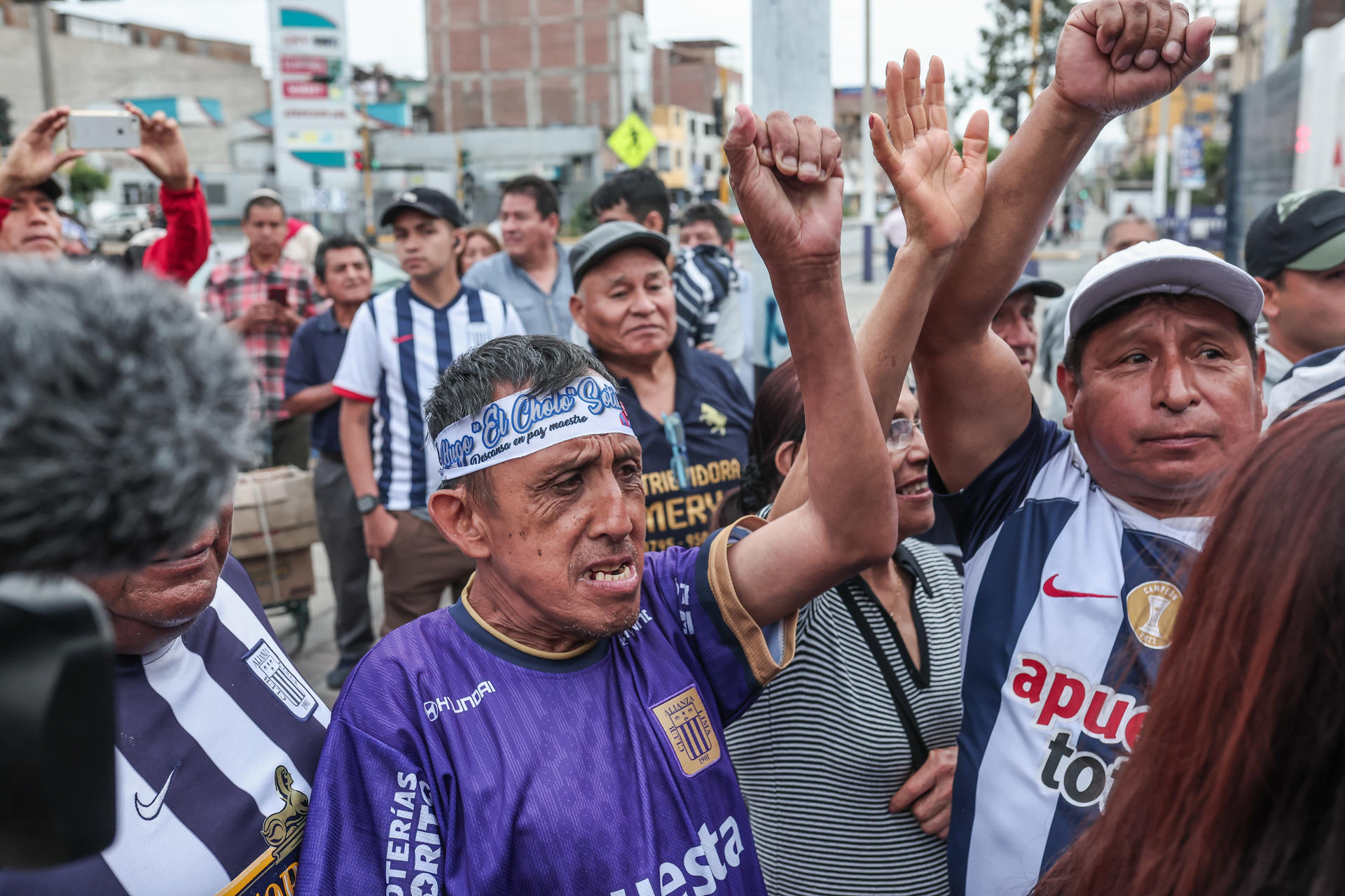 Aficionados se congregaron este lunes en la entrada del estadio del club Alianza Lima a donde fueron conducidos los restos del exfutbolista peruano Hugo 'el Cholo' Sotil. EFE/ Aldair Mejía
