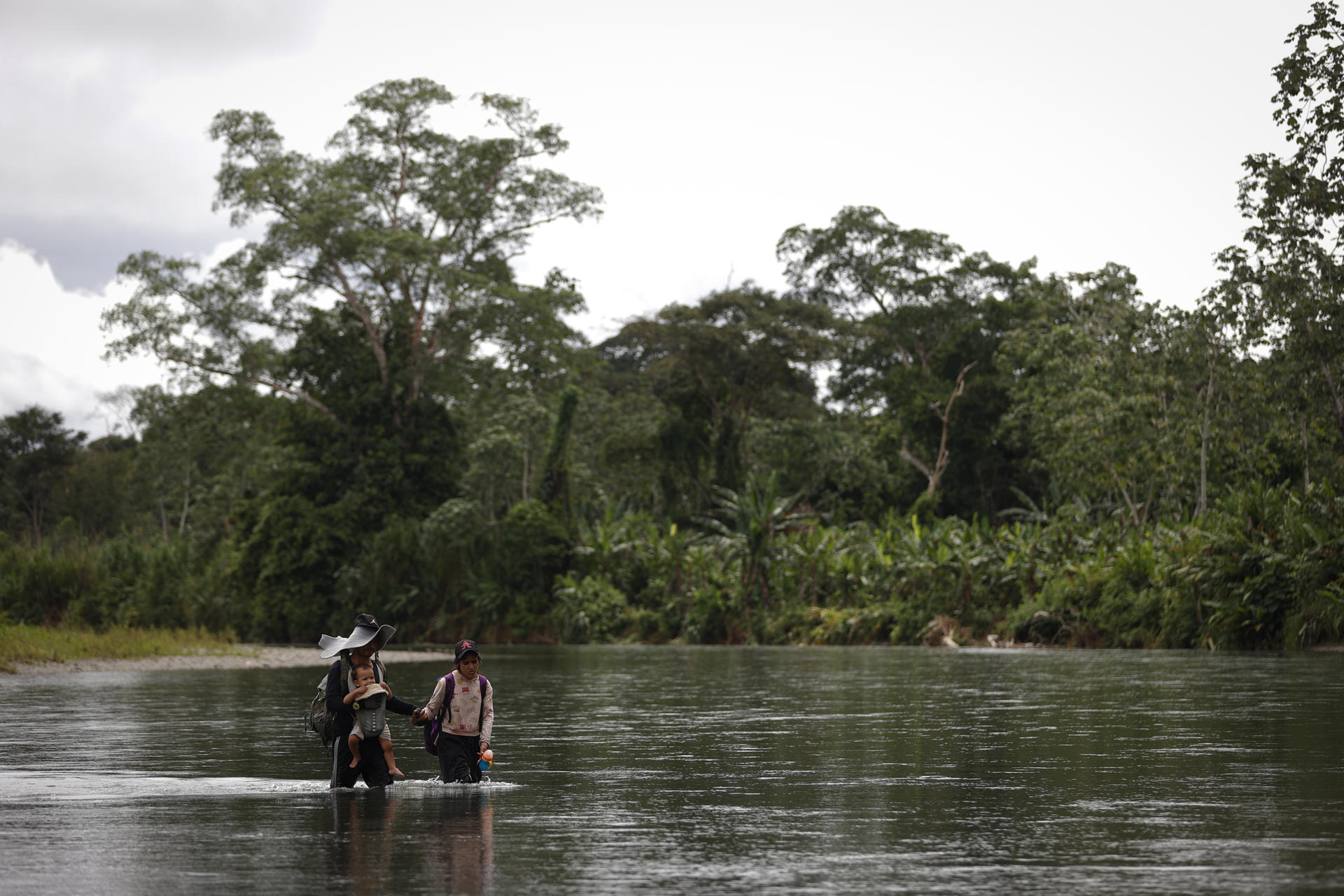 Fotografía de archivo del 2 de noviembre de 2024 de Luis, un migrante venezolano cargando a su hijo Matías Infante de 1 año junto a su esposa Sharon Morales, a través del río Tuquesa, en Bajo Chiquito, Darien (Panamá). EFE/ Bienvenido Velasco
