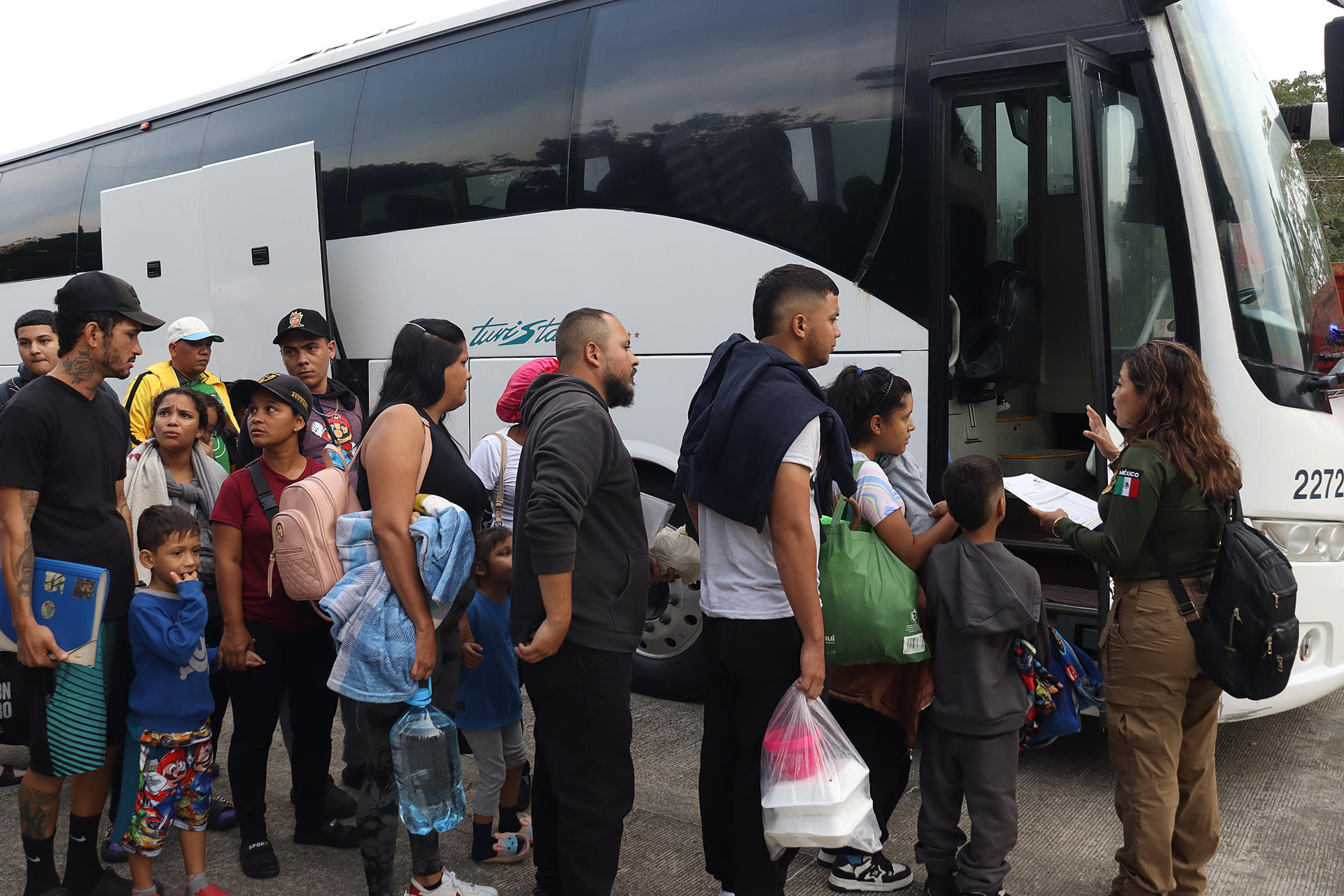 Migrantes hacen fila para abordar autobuses este viernes, en el municipio de Tapachula en Chiapas (México). EFE/ Juan Manuel Blanco
