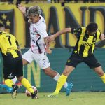 Elian Irala (c) de San Lorenzo busca eludir la marca de dos rivales de Peñarol este jueves, en el partido de pretemporada correspondiente a la Serie Río de la Plata, que ganó el conjunto argentino por 1-2 en estadio Campeón del Siglo de Montevideo. EFE/ Gastón Britos