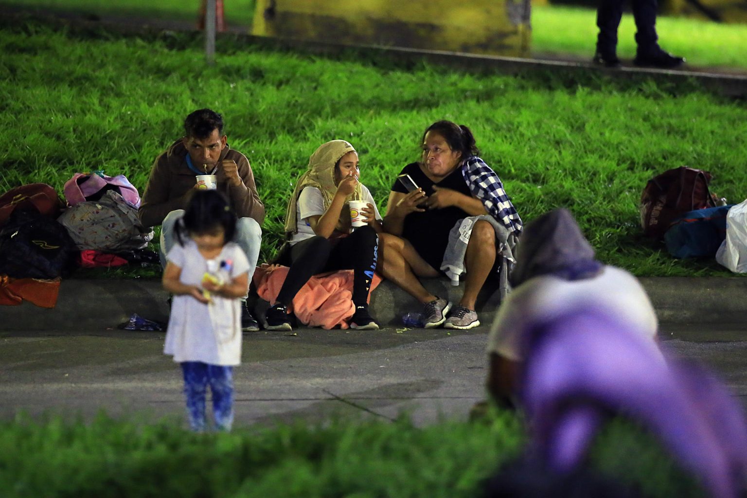 Una familia hondureña come antes de salir en una caravana de migrantes este lunes, en San Pedro Sula (Honduras) con rumbo a la frontera de Guatemala. EFE/ Jose Valle