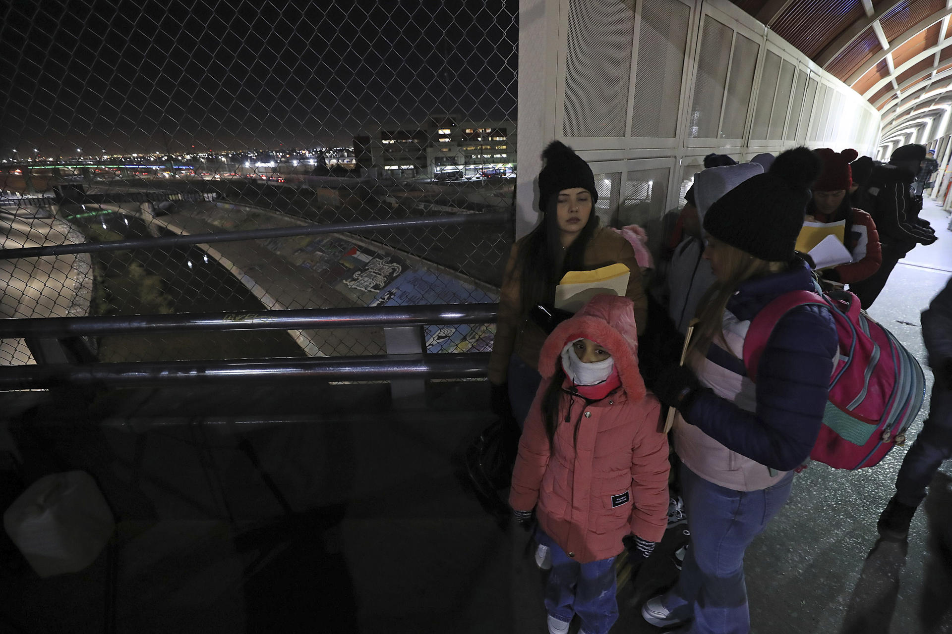 Migrantes esperan en una fila en el puente Internacional Paso del Norte, este lunes en Ciudad Juárez (México). EFE/ Luis Torres
