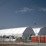 Personas laboran en la construcción de un albergue temporal para migrantes este miércoles, en el Gimnasio Alianza del municipio El Carmen en Nuevo León (México). EFE/ Miguel Sierra