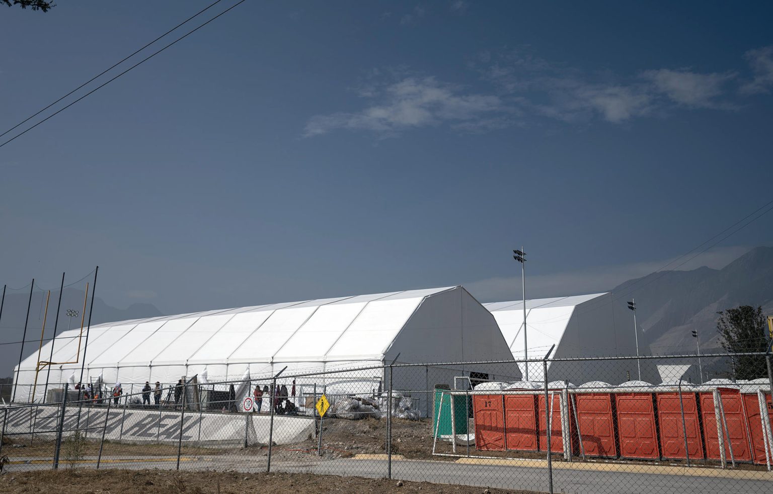 Personas laboran en la construcción de un albergue temporal para migrantes este miércoles, en el Gimnasio Alianza del municipio El Carmen en Nuevo León (México). EFE/ Miguel Sierra