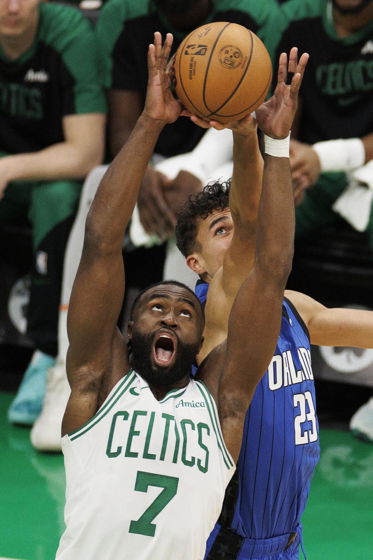 El escolta de los Boston Celtics, Jaylen Brown (d) se exige a fondo para bajar un balón que también pretende el alero de los Orlando Magic, Tristan da Silva (d), durante el partido jugado este viernes en Boston (Massachusetts), que los locales ganaron por 121-94. EFE/EPA/CJ GUNTHER