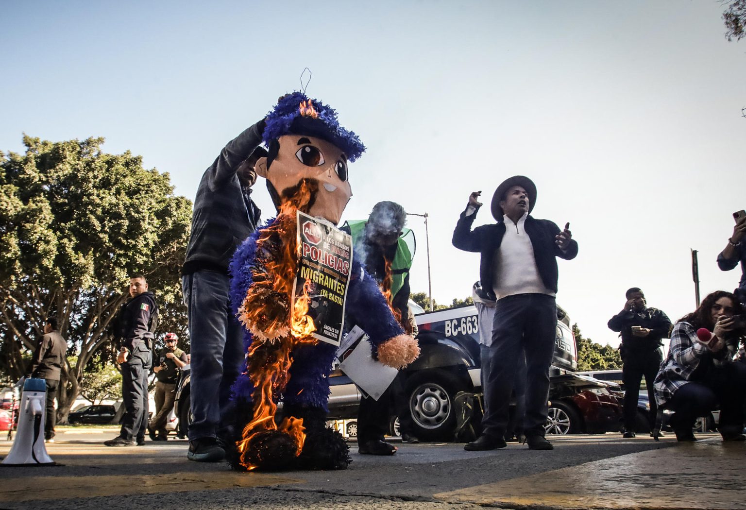 Imagen de archivo de activistas promigrantes de la ciudad mexicana de Tijuana, fronteriza con Estados Unidos, que llevaron a cabo la quema de una piñata de cartón, con la figura de un policía municipal, a manera de protesta por los abusos y delitos que los agentes de la corporación de seguridad cometen en contra de la población migrante. EFE/Joebeth Terriquez