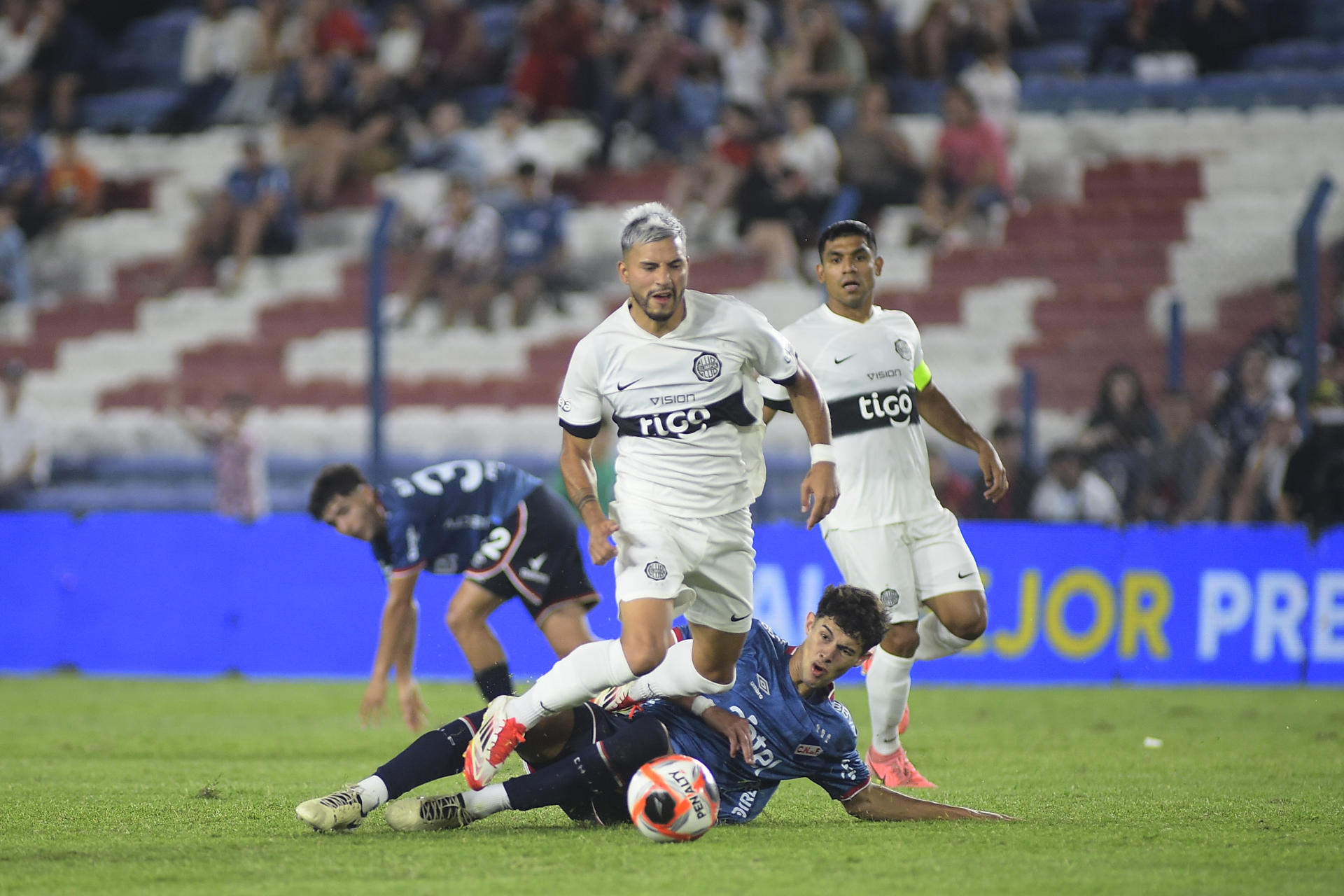 Iván Leguizamón, jugador de Olimpia, avanza con el balón tras dejar en el piso a Rodrigo Mederos, de Nacional, durante el partido de la Serie Río de La Plata que el equipo paraguayo ganó este viernes por 0-2 en el estadio Gran Parque Central de Montevideo. EFE/ STR
