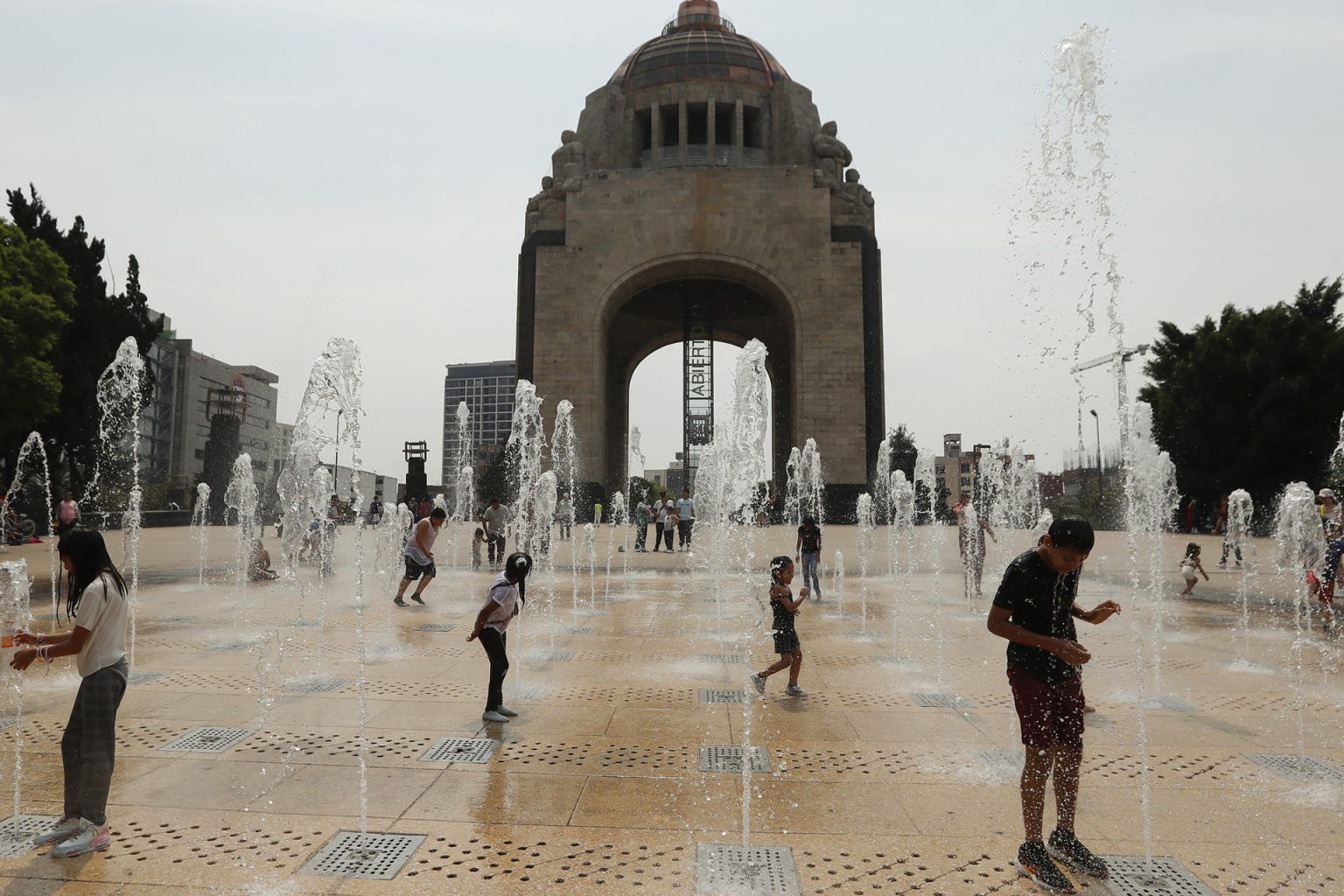 Personas juegan en una fuente del Monumento a la Revolución en la Ciudad de México (México). EFE/ Mario Guzmán