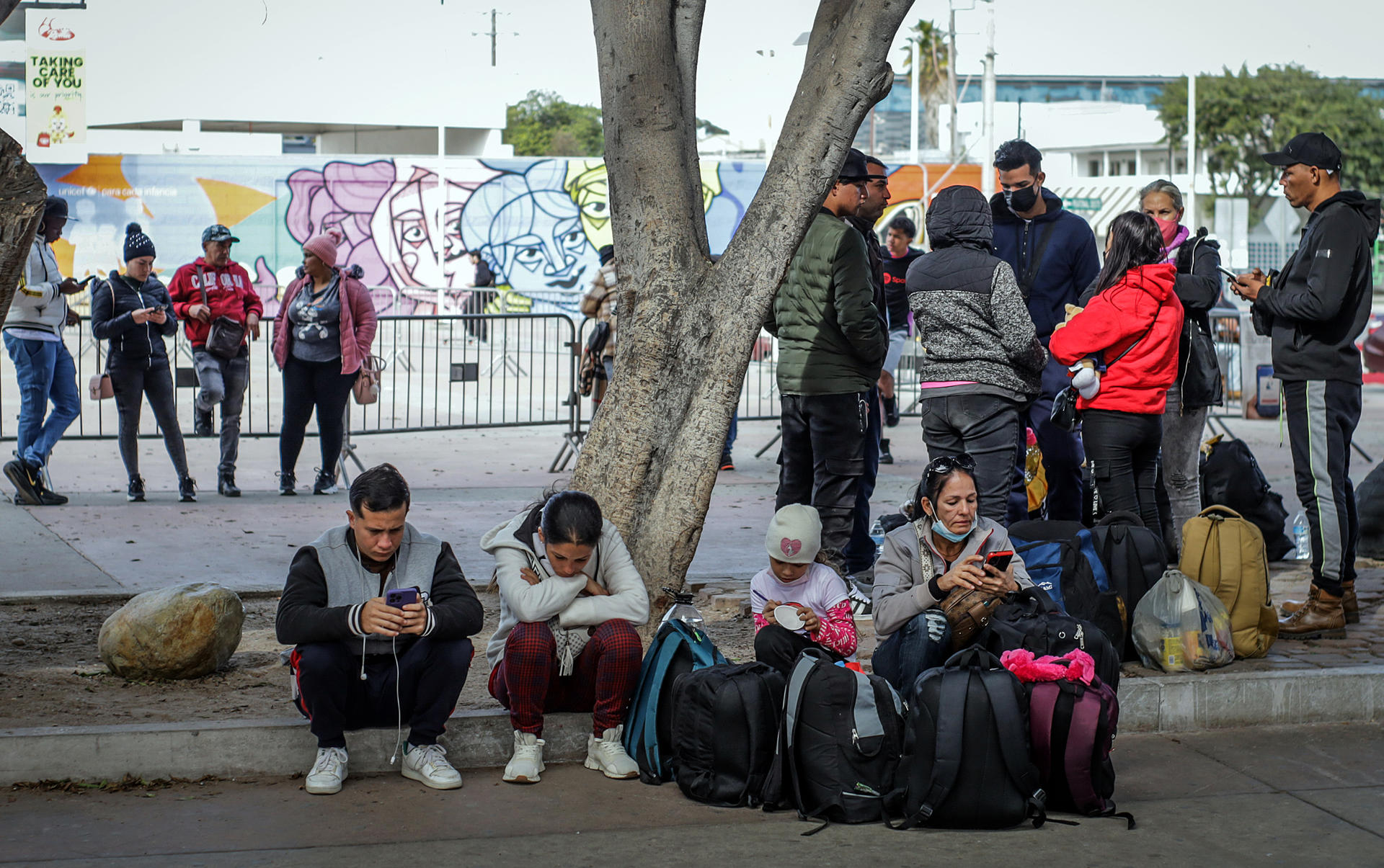 Un grupo de migrantes deportados, permanecen este miércoles en el puerto fronterizo de El Chaparral, en Tijuana (México). EFE/ Joebeth Terríquez
