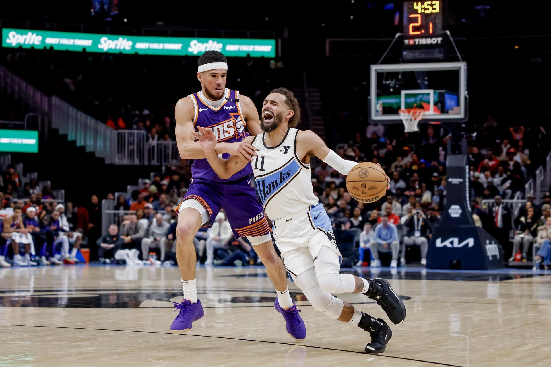 El base de Atlanta Hawks, Trae Young (d) avanza ante la marca de Devin Brooker (i) durante el partido perdido por los Phoenix Suns (122-117) en Atlanta (Georgia) EFE/EPA/ERIK S. LESSER
