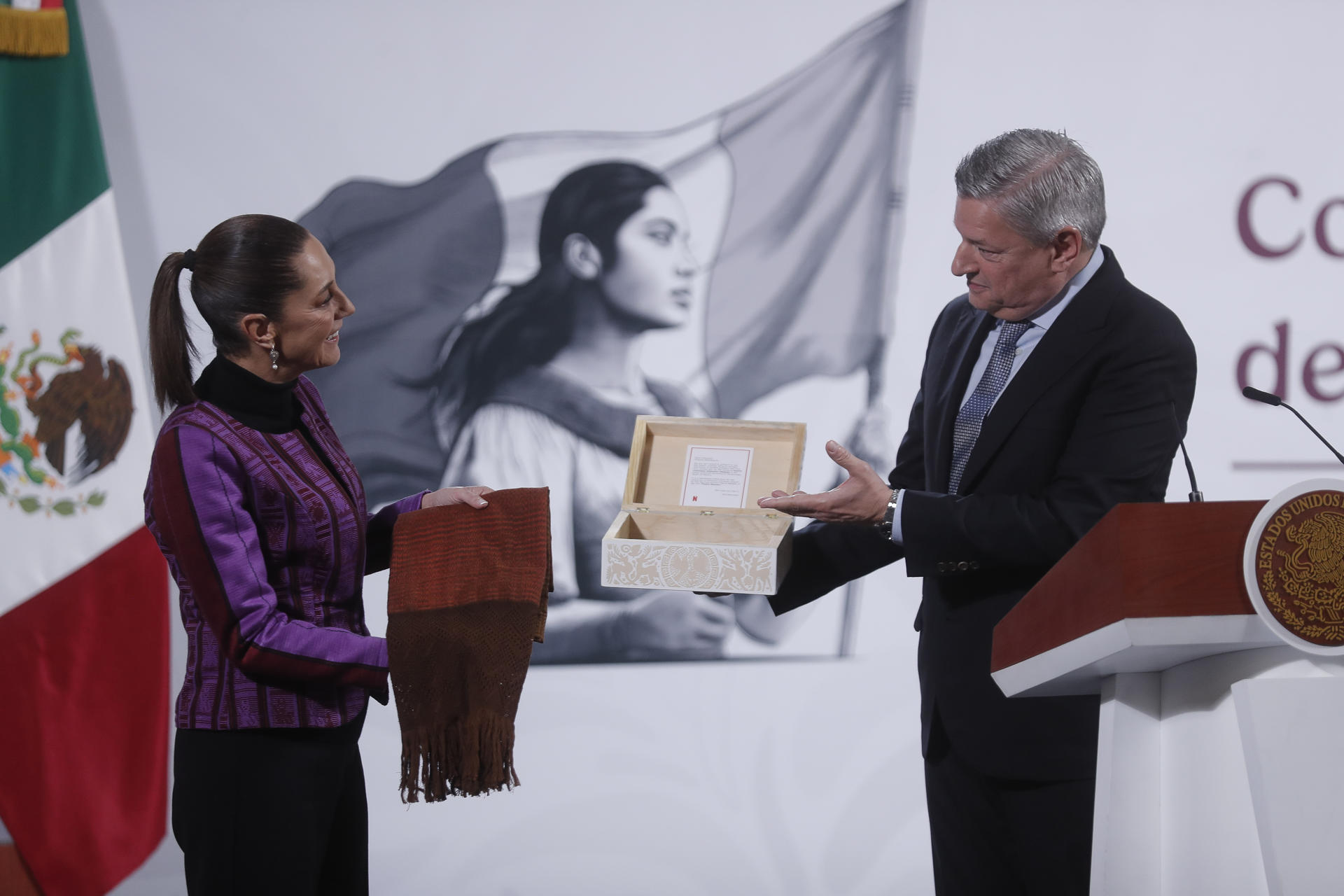 El director ejecutivo de Netflix, Ted Sarandos (d), entrega un obsequio a la presidenta mexicana, Claudia Sheinbaum, durante la conferencia matutina de Sheinbaum este jueves, en el Palacio Nacional de la Ciudad de México (México). EFE/ Isaac Esquivel
