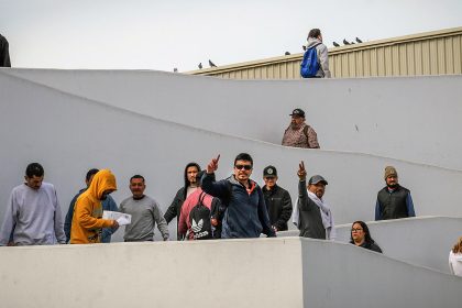 Imagen de archivo de migrantes deportados que saludan en el puerto fronterizo de El Chaparral, este miércoles en Tijuana (México). EFE/ Joebeth Terríquez