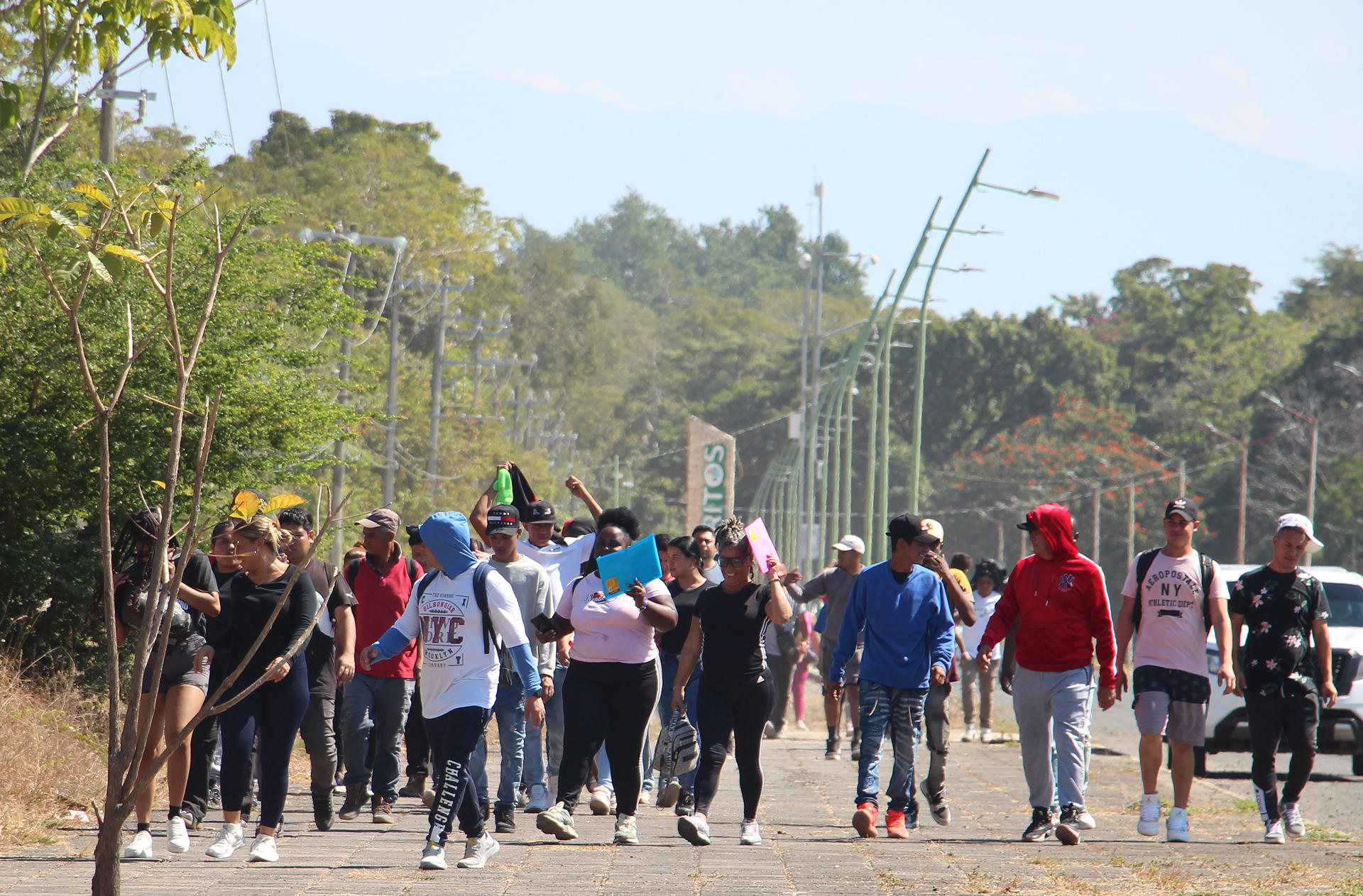 Migrantes caminan después de regresar de la Comisión Mexicana de Ayuda a Personas Refugiadas (Comar), en espera de resolver su situación migratoria este jueves en la ciudad de Tapachula en el estado de Chiapas (México). EFE/Juan Manuel Manuel Blanco
