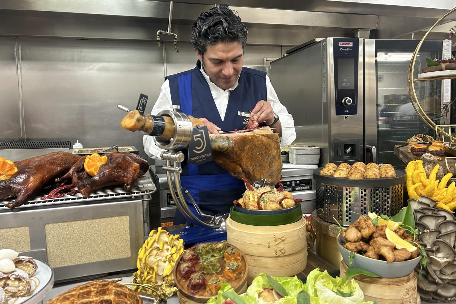 El maestro cortador de Cinco Jotas, Raúl Garrido, corta jamón este jueves, en las cocinas del teatro Dolby en Los Ángeles (Estados Unidos). EFE/ Mikaela Viqueira