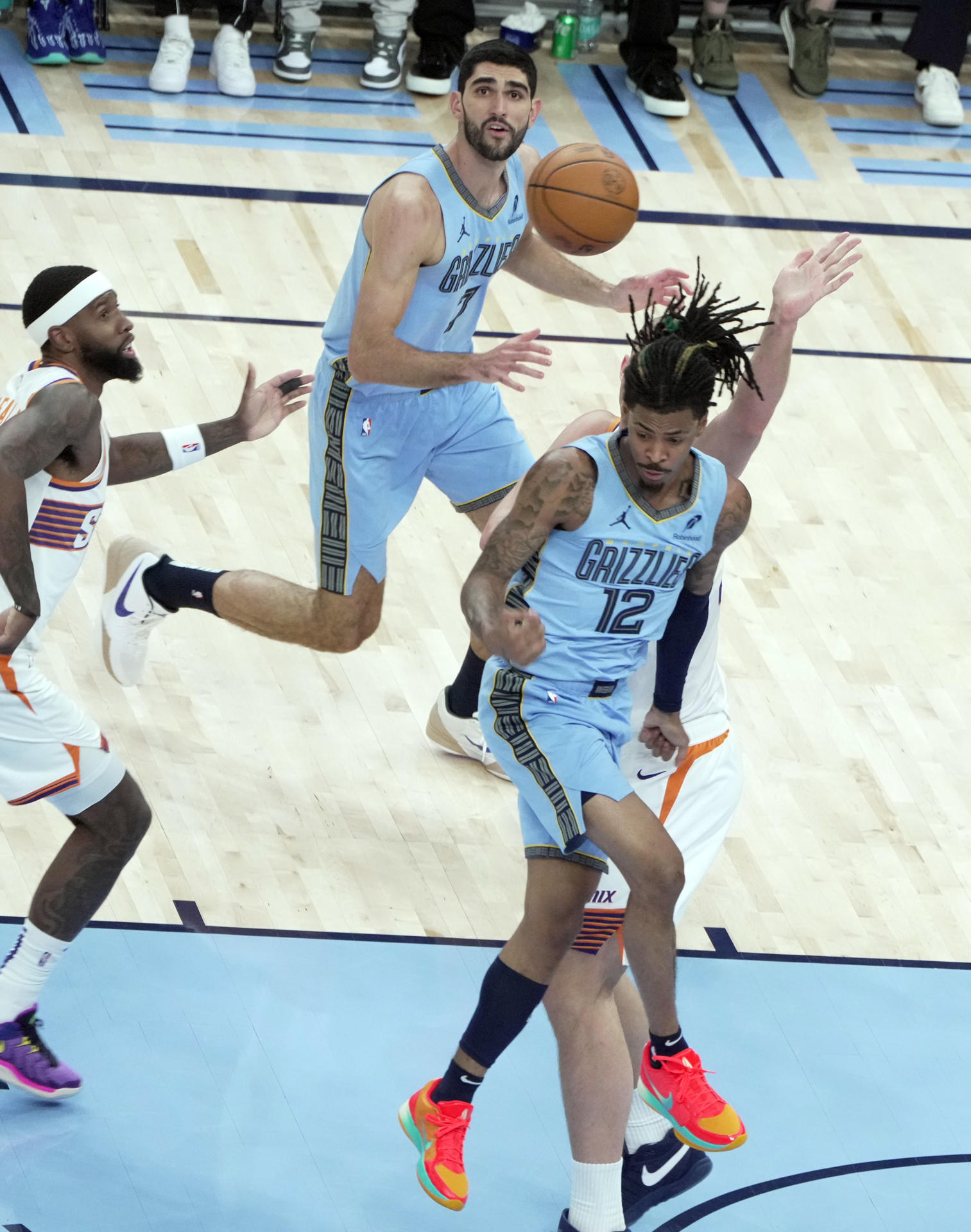 Ja Morant (frente) de Grizzlies le pasa el balón a su compañero Santi Aldama (arriba) este martes, durante el partido Grizzlies-Suns. EFE/ Karen Pulfer Focht
