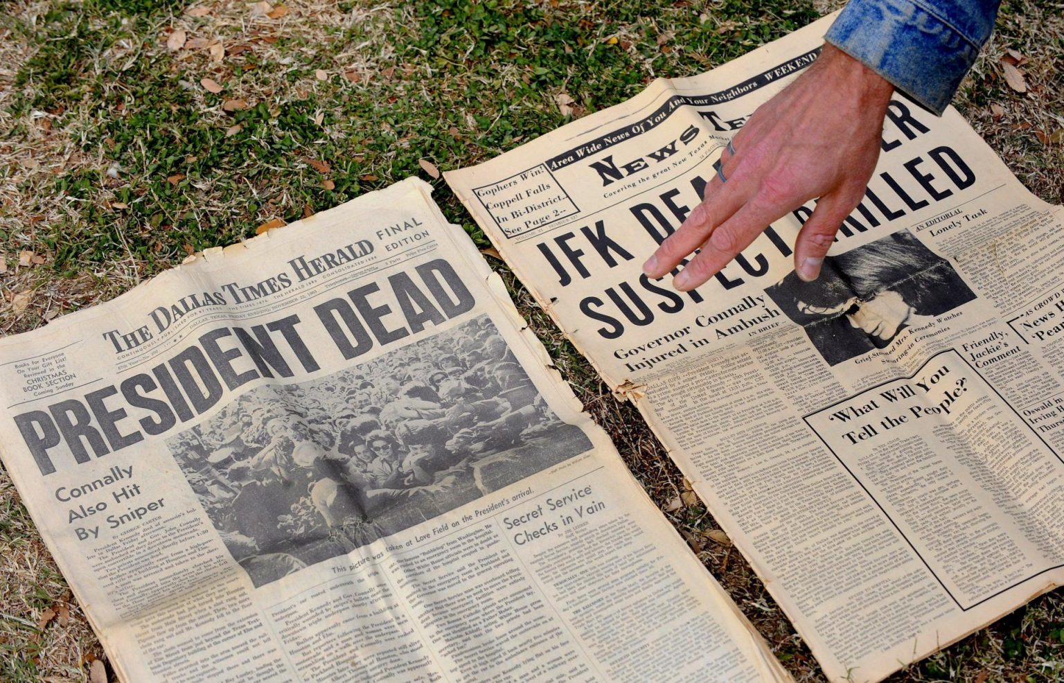 Imagen de archivo de un hombre que muestra un periódico de 1963 que informa sobre el asesinato de Kennedy en el monumento en memoria de John F. Kennedy en Dealey Plaza, el lugar donde fue asesinado, en Dallas, Texas, EEUU. EFE/Larry W. Smith