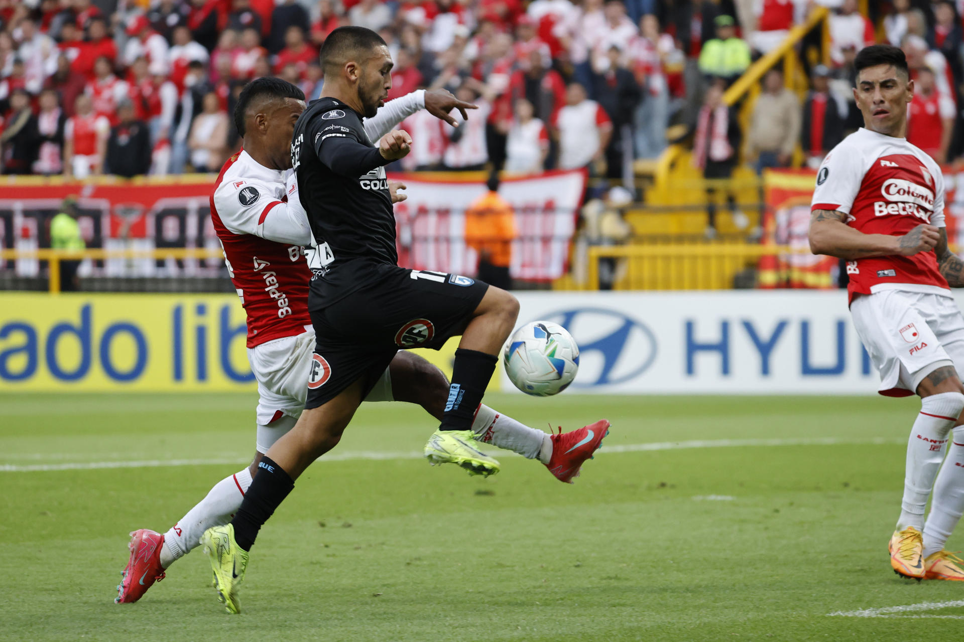 César González (c), de Iquique, avanza con el balón en un pasaje del partido de Copa Libertadores jugado en el estadio de Techo en Bogotá. EFE/ Mauricio Dueñas Castañeda
