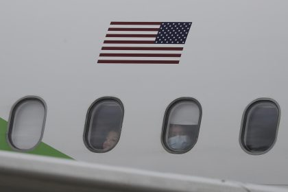 Migrantes provenientes de Estados Unidos observan por la ventana de un avión en el que fueron enviados de regreso a casa. EFE/ Jeffrey Arguedas