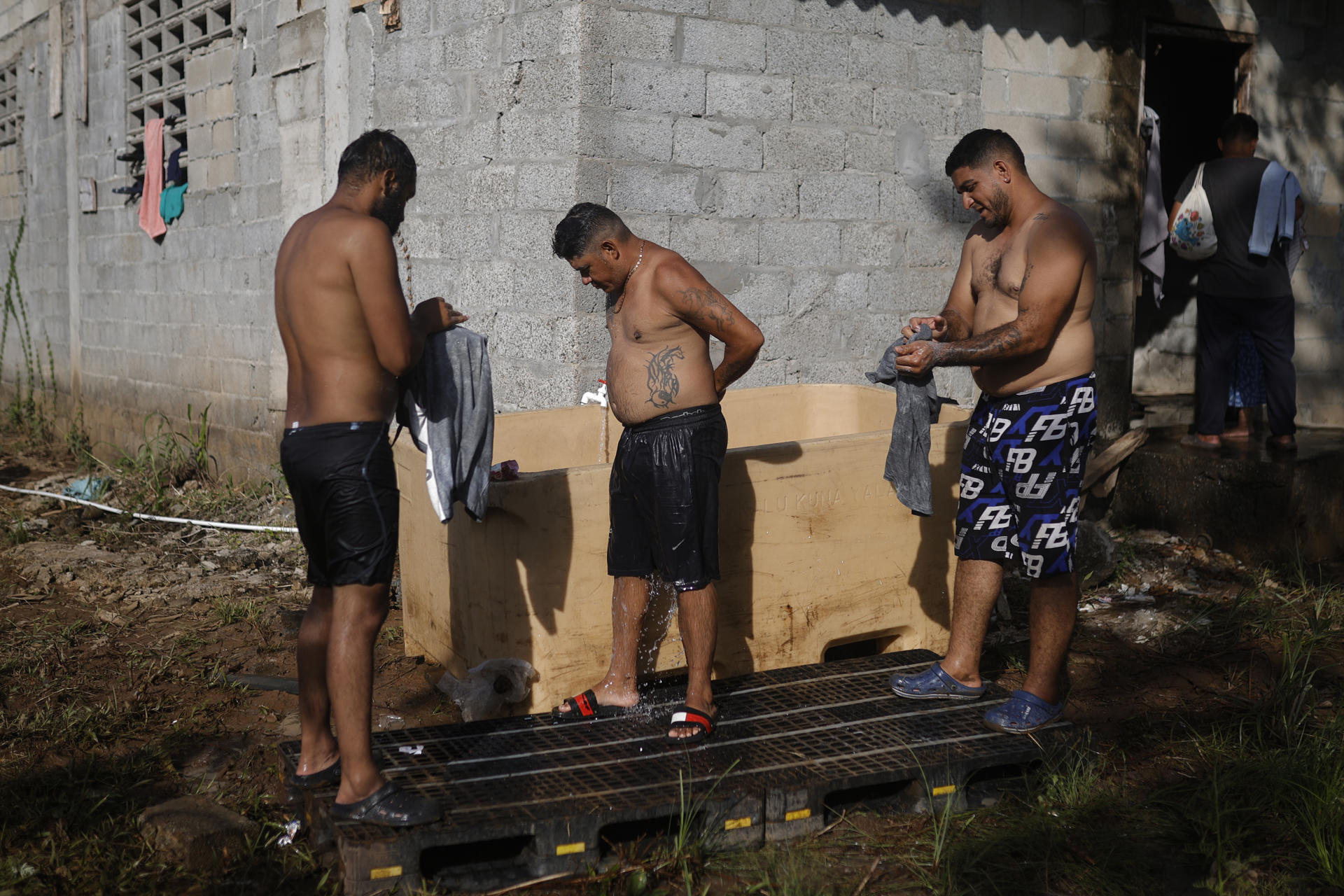 Los venezolanos Jayson Querales (i), Roy Dimarques (c), y José Luis Viloria se bañan este miércoles, en el corregimiento de Miramar en la provincia de Colón (Panamá). EFE/ Bienvenido Velasco
