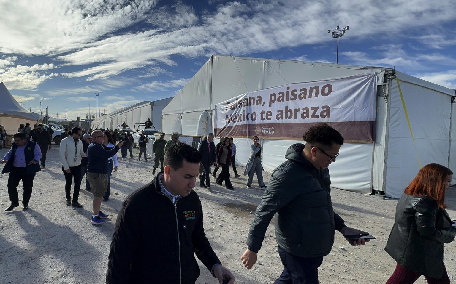 Personas caminan frente al nuevo centro de apoyo y de servicios de la estrategia 'México te abraza' este jueves, en Ciudad Juárez (México). EFE/ Luis Torres