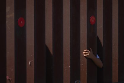 Fotografía de archivo de un niño tocando el muro fronterizo sur entre Estados Unidos y México en San Diego, California (Estados Unidos). EFE/EPA/ALLISON DINNER