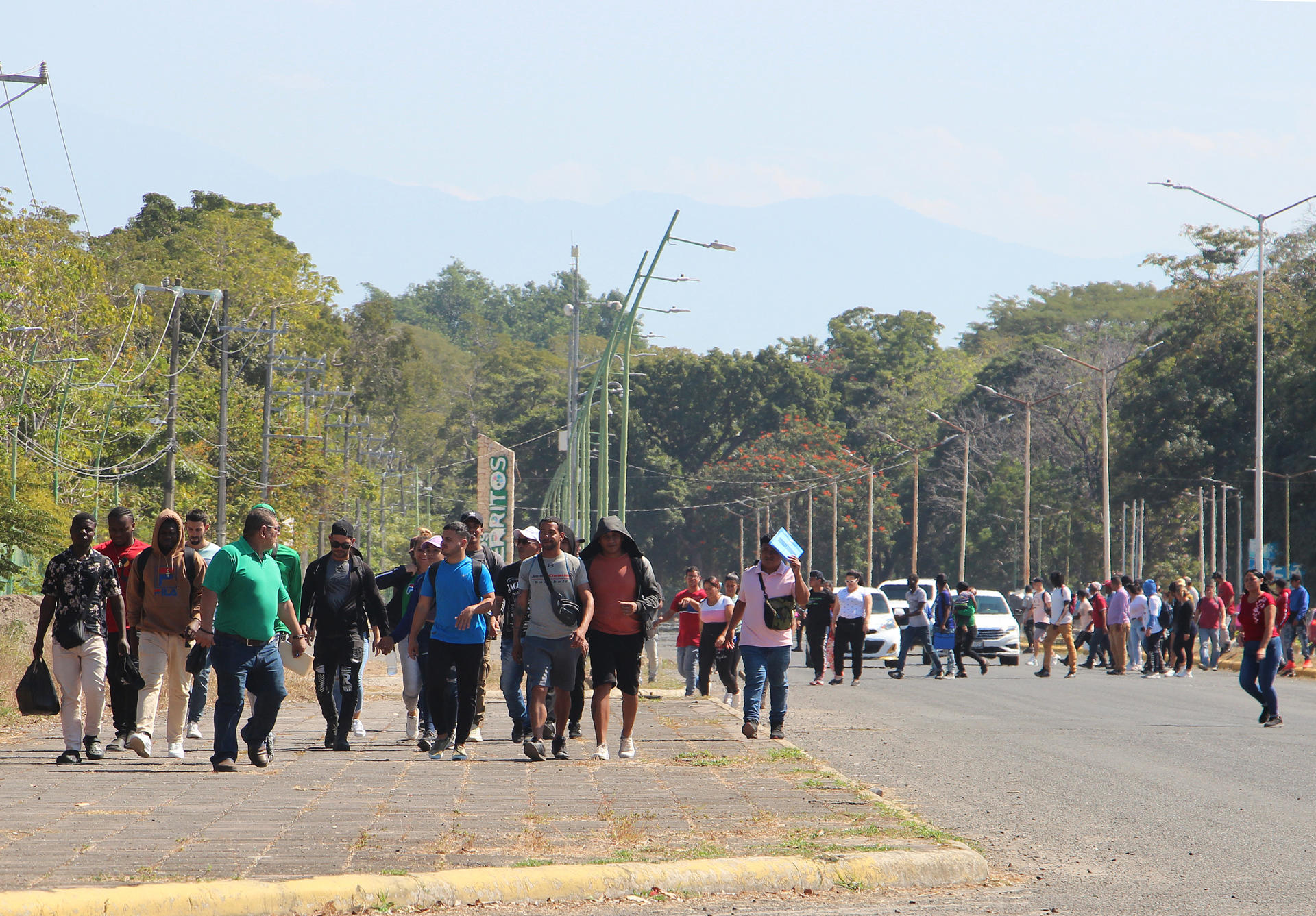 Migrantes caminan después de regresar de la Comisión Mexicana de Ayuda a Personas Refugiadas (Comar), en espera de resolver su situación migratoria este jueves en la ciudad de Tapachula en el estado de Chiapas (México). EFE/Juan Manuel Manuel Blanco
