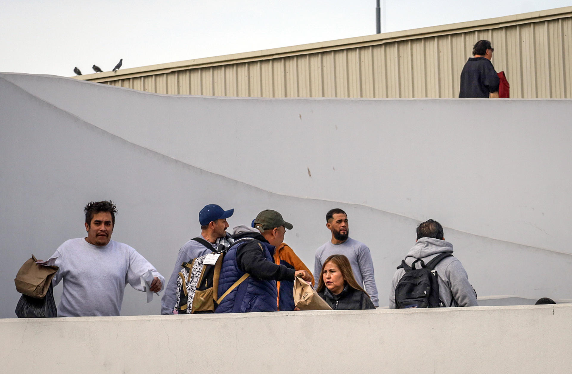 Migrantes deportados ayer, son vistos en el puerto fronterizo de El Chaparral, en Tijuana (México). EFE/ Joebeth Terríquez
