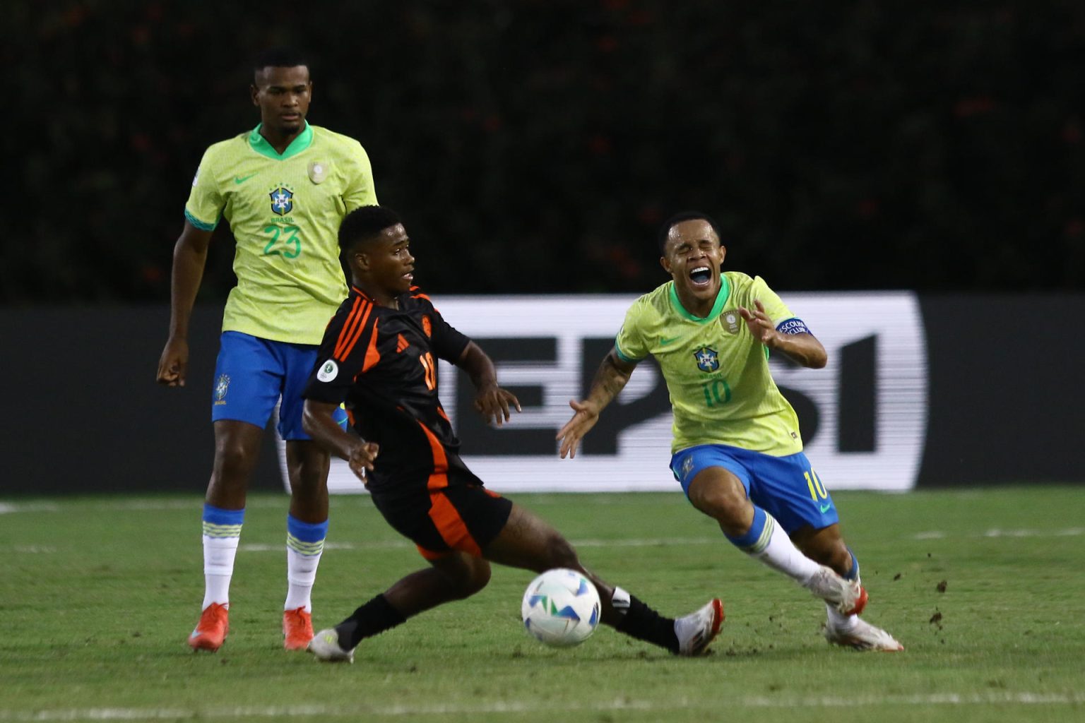 El brasileño Pedro Silva (d) disputa el balón con el colombiano Julian Bazan (c) este sábado, durante el partido que los cafeteros ganaron por 0-1 a la Canarinha en el cierre del Grupo B del Campeonato Sudamericano Sub-20 jugado en el estadio Polideportivo Misael Delgado de la ciudad venezolana de Valencia. EFE/ Juan Carlos Hernández