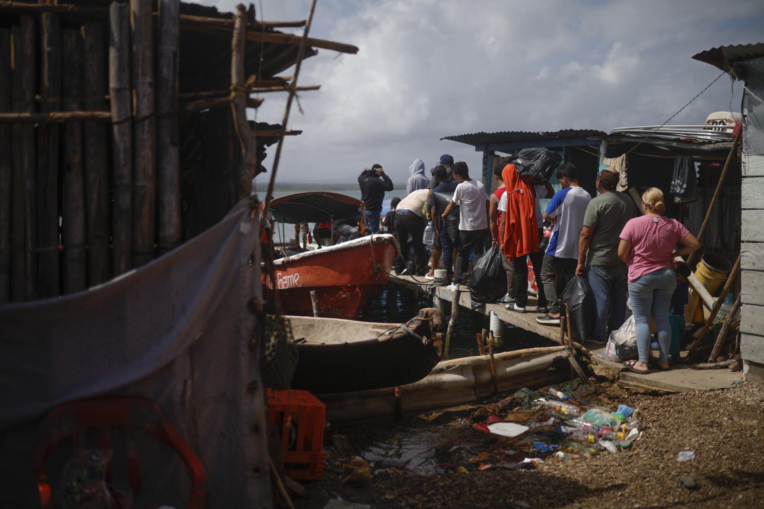 Migrantes venezolanos y colombianos hacen fila para abordar una embarcación en la isla Gardi Sugdub con destino a Colombia este domingo, en la comarca Guna Yala, en Puerto de Cartí (Panamá). EFE/ Bienvenido Velasco