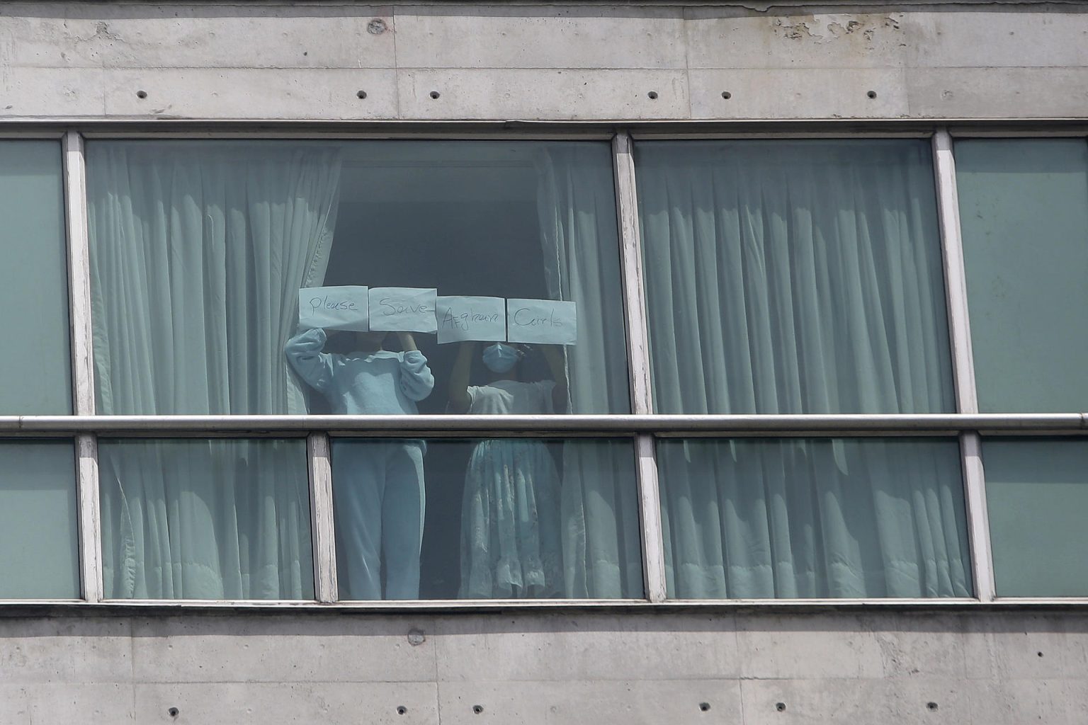 Personas muestran un cartel en una ventana del hotel Decápolis este martes, en Ciudad de Panamá (Panamá). EFE/ Carlos Lemos