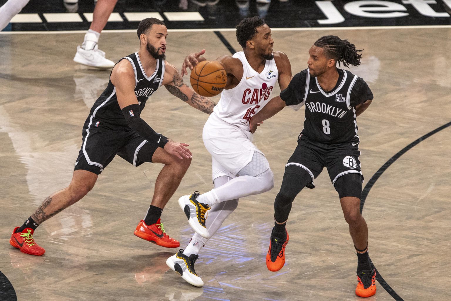 Tyrese Martin (i) y Ziaire Williams, de los Brooklyn Nets, intentan marcar a Donovan Mitchell de los Cleveland Cavaliers en el partido de la NBA en el Barclays Center de Nueva York (Estados Unidos). EFE/ Ángel Colmenares