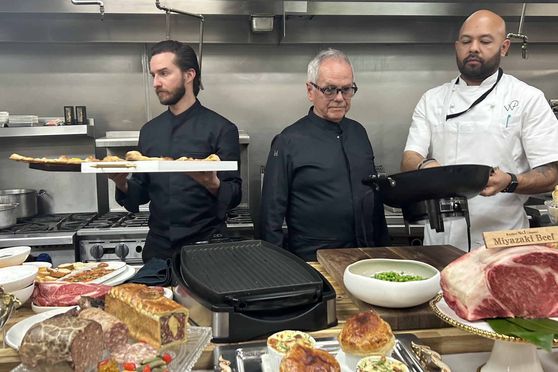 Wolfgang Puck (c), chef de los Óscar, supervisa las preparaciones junto a su hijo Byron Puck (i) y un ayudante de cocina este jueves, en las cocinas del teatro Dolby en Los Ángeles (Estados Unidos). EFE/ Mikaela Viqueira
